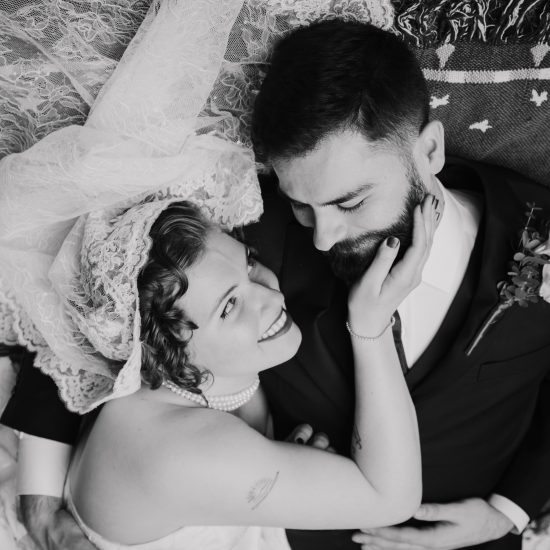 Bride and groom sharing an intimate moment in a garden courtyard, standing together in wedding attire.